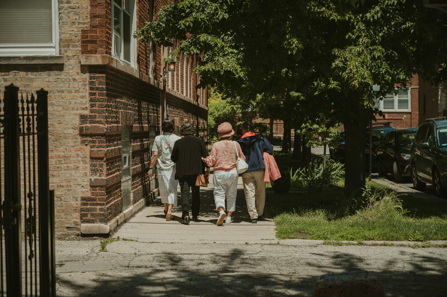 A diverse group of women walking together on a sunny day in a Chicago neighborhood street.