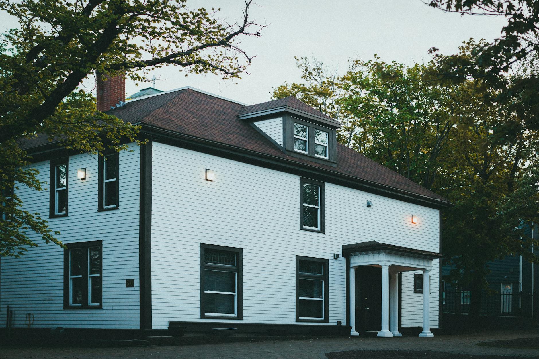 A beautifully lit traditional house exterior photographed at dusk, highlighting its architectural features.